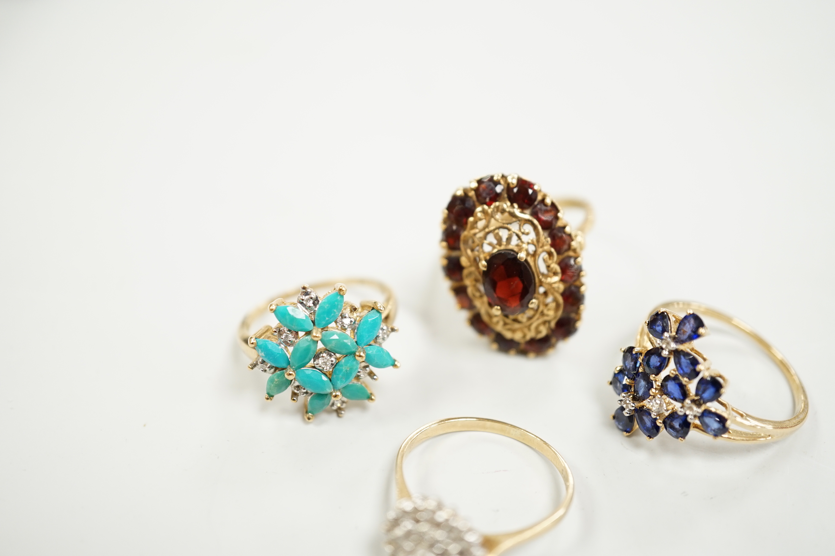 Four assorted modern 9ct gold and gem set dress rings including diamond cluster and garnet cluster, gross weight 13.6 grams.